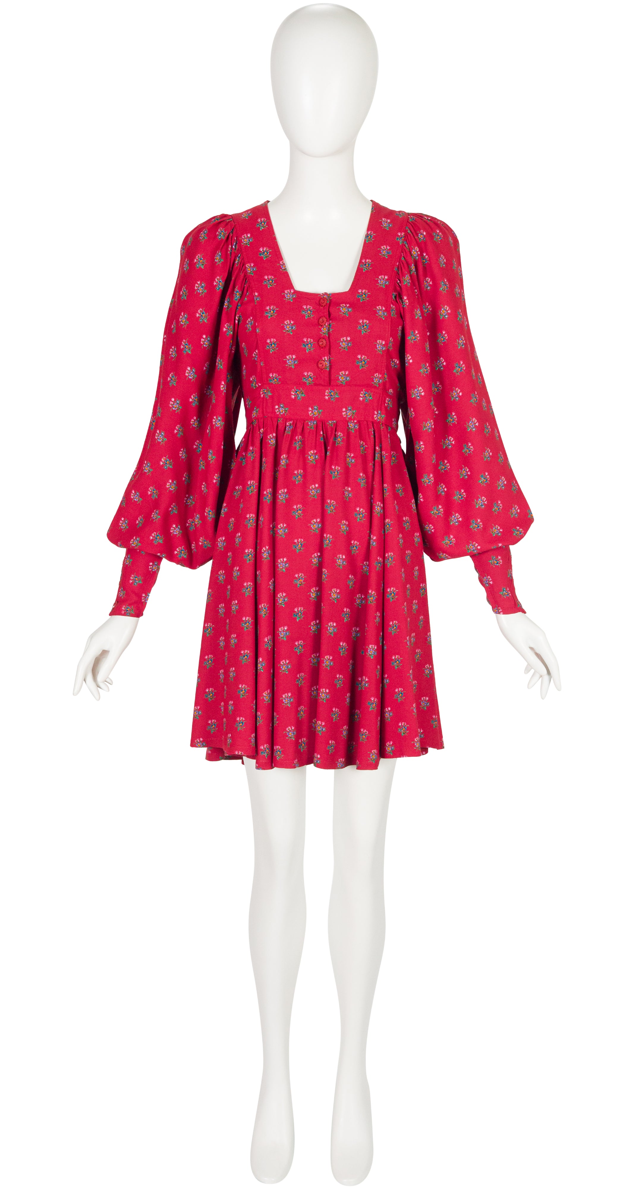 A 1970s Jeff Banks red puff-sleeve mini dress with a small repeating floral pattern, displayed on a white mannequin against a plain white background.