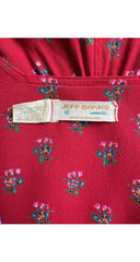 Close-up of a red fabric garment with a small multicolor floral print and a visible Jeff Banks London label.