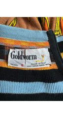 Close-up of a Goldworm knit garment showing a striped pattern with black, light blue, orange, and brown horizontal bands, along with a white brand label.