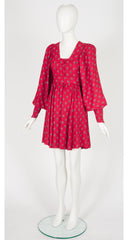 A 1970s Jeff Banks red and pink patterned mini dress with voluminous puff sleeves and a square neckline, displayed on a white mannequin against a light gray background.